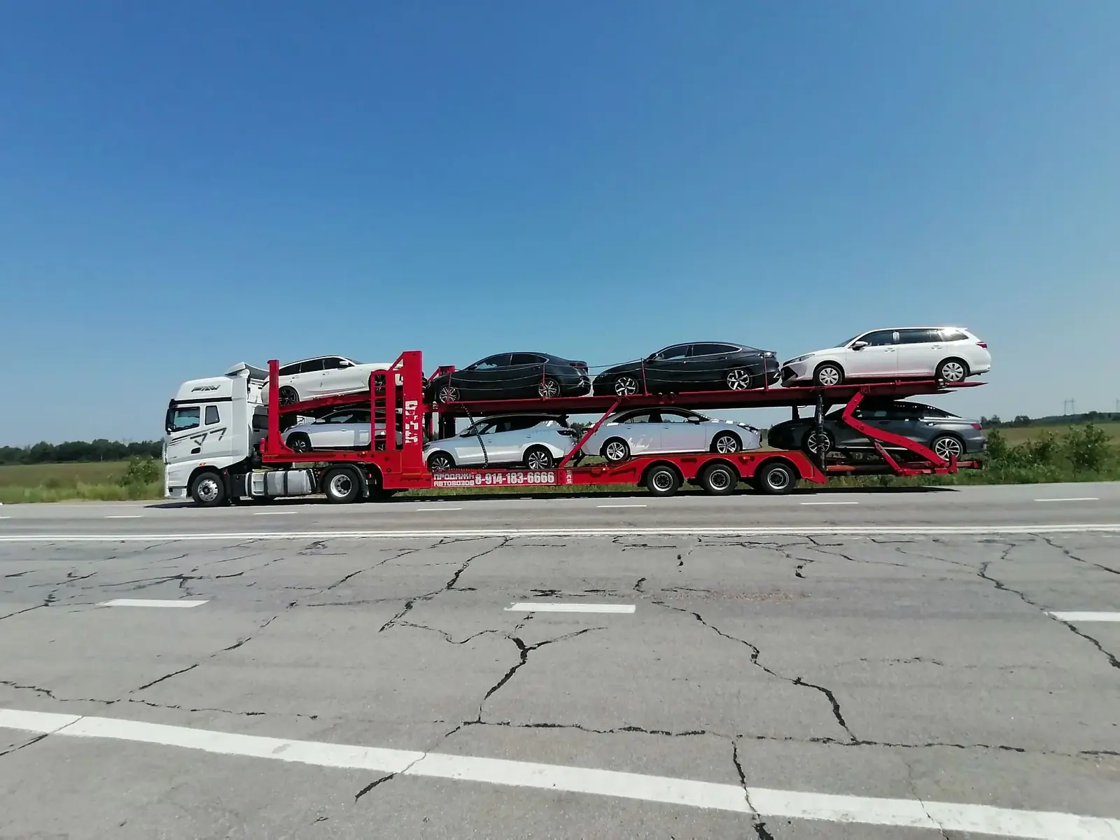 Автовоз FAW с автомобилями на трассе